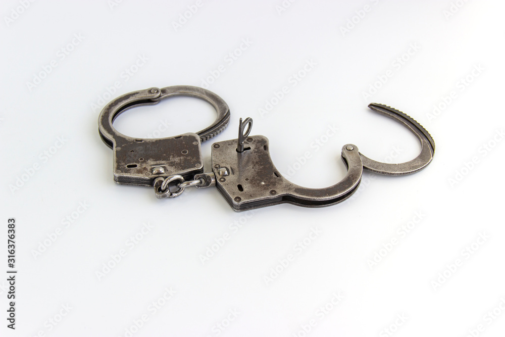the key of the house in handcuffs, isolated on white background the key of the house in handcuffs, isolated on white background