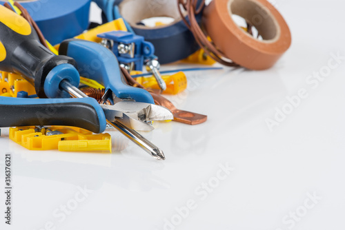Electrical accessories and hand tools on white workshop table