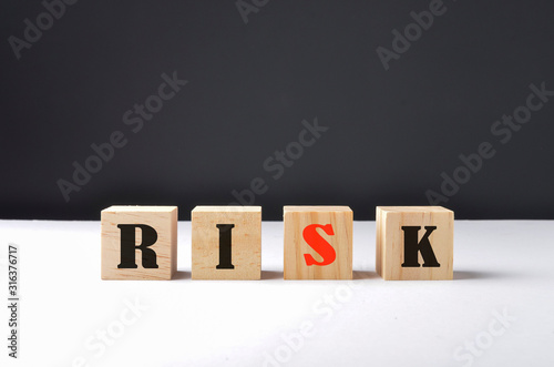 Fototapeta Naklejka Na Ścianę i Meble -  RISK word written on wooden cubes. Financial risk assessment, risk reward and portfolio risk management concept. Selective focus.