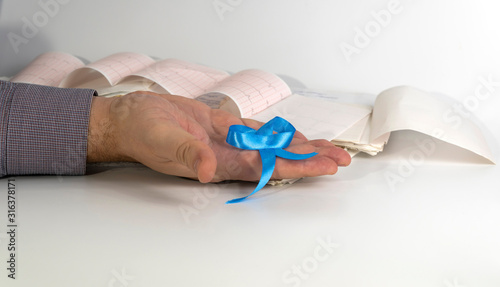 blue ribbon in a man's hand on a white background.