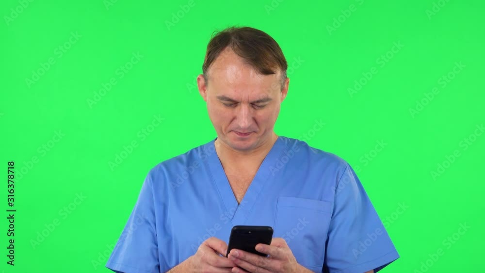 Medical man texting on him phone and rejoice. Green screen Medical man texting on him phone and rejoice. Green screen