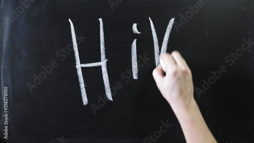 The word hi to black chalkboard. The sign is written on a chalk board. Male hand draws in chalk on a blackboard photo