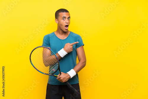 African American tennis player man surprised and pointing side © luismolinero