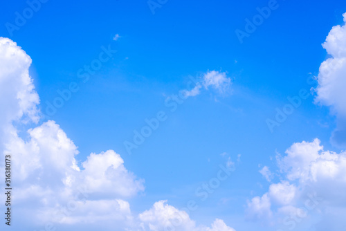 The blue summer sky with white fluffy clouds. Photo from window on the airplane.