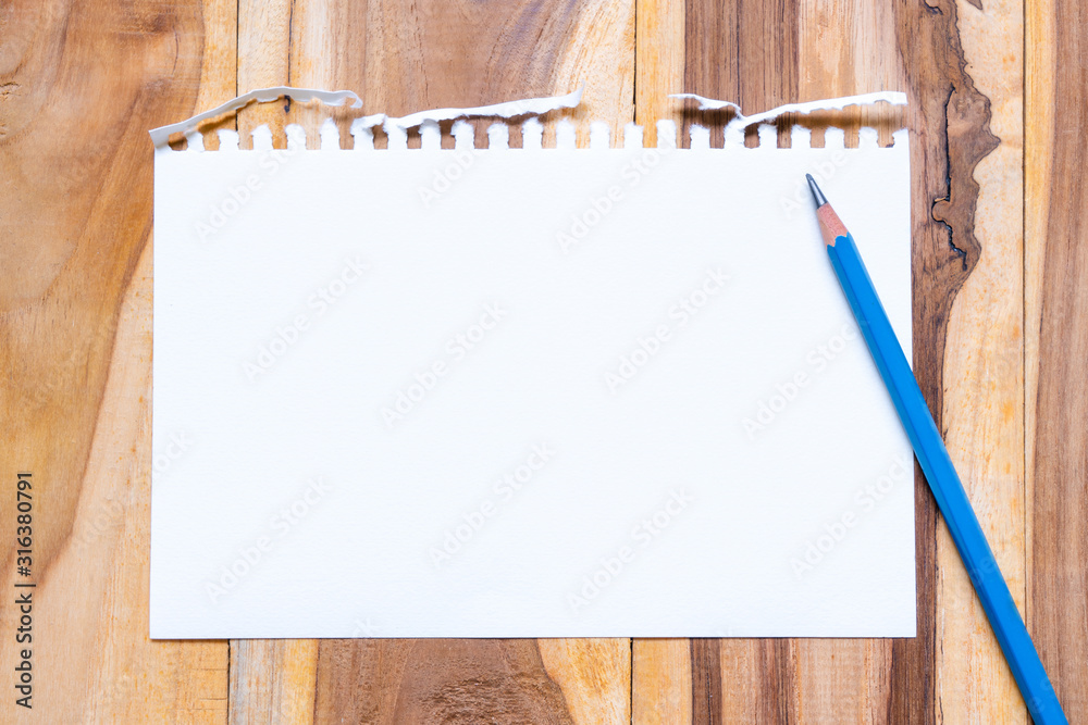 Empty paper sheet on brown wooden table surface for background. Copy space for add text or art work designs. Empty paper sheet on brown wooden table surface for background. Copy space for add text or art work designs.
