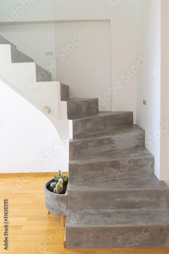 Microcement grey colour on staircase with matt finish, in combination with white walls and natural wooden floor photo