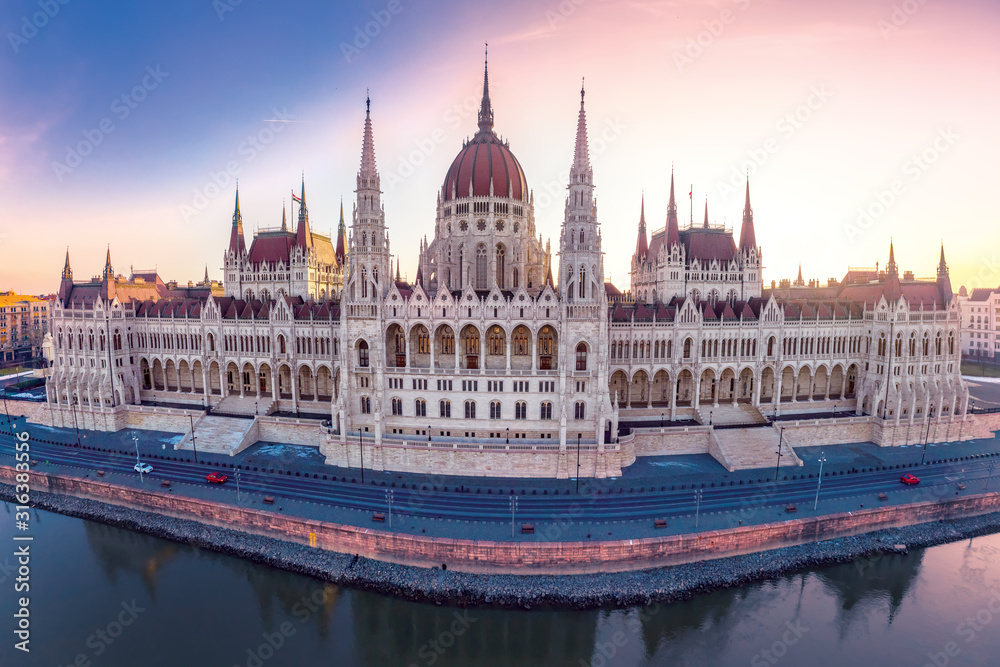 Fototapeta premium Hungarian Parliament Building on the bank of the river Danube in Budapest at night, aerial photo