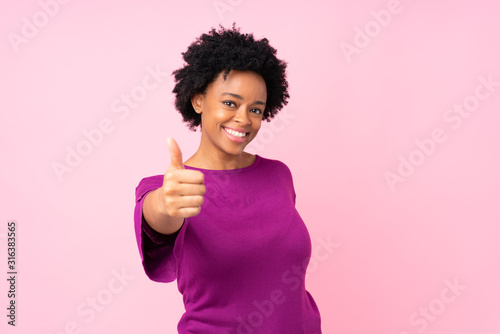 African american woman over isolated pink background with thumbs up because something good has happened