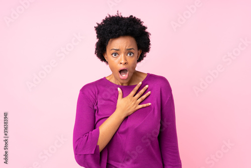 Fotografie, Obraz African american woman over isolated pink background surprised and shocked while