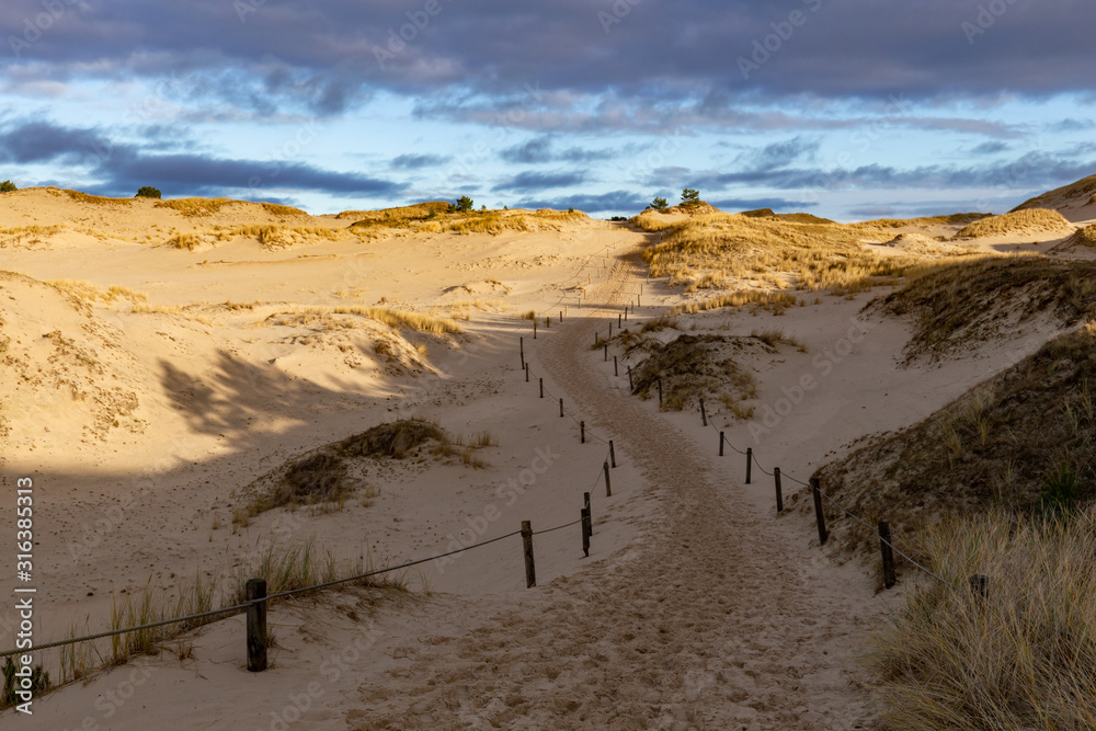 Dunes in the Slowinski National Park. Landscape with beautiful sky, clouds and dunes in the sun. Czolpino, Leba, Poland.