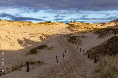 Obraz na płótnie Dunes in the Slowinski National Park. Landscape with beautiful sky, clouds and dunes in the sun. Czolpino, Leba, Poland. w salonie