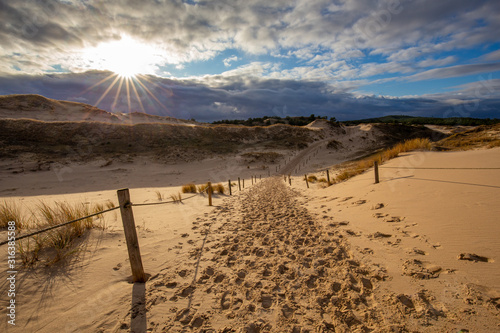 Obraz na płótnie Dunes in the Slowinski National Park. Landscape with beautiful sky, clouds and dunes in the sun. Czolpino, Leba, Poland. w salonie
