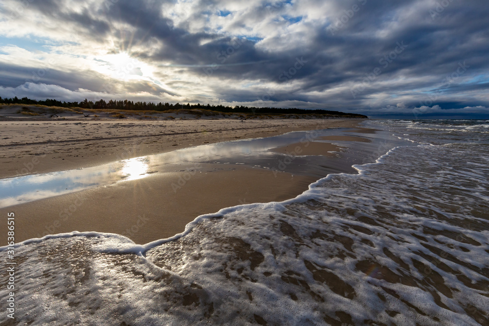 A beach after a storm during a windy evening in the Slowinski National Park. Czolpino, Leba, Poland.