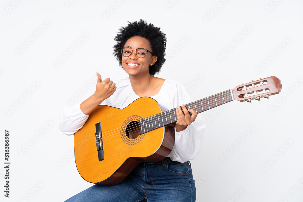 African american woman with guitar over isolated background pointing to the side to present a product African american woman with guitar over isolated background pointing to the side to present a product