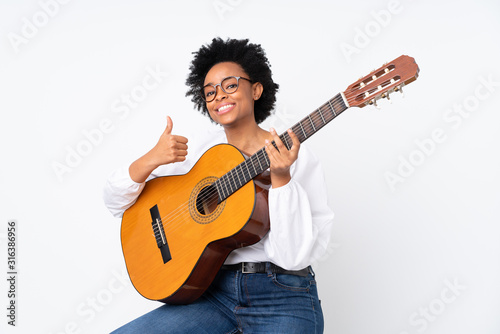 African american woman with guitar over isolated background with thumbs up because something good has happened