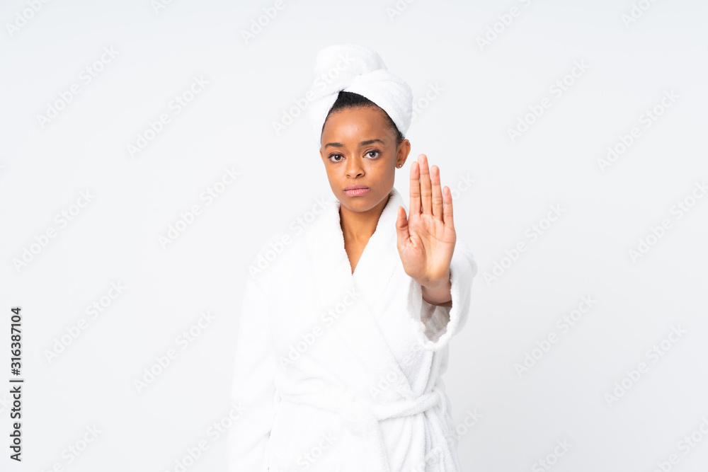 African american woman in a bathrobe over isolated background making stop gesture with her hand African american woman in a bathrobe over isolated background making stop gesture with her hand