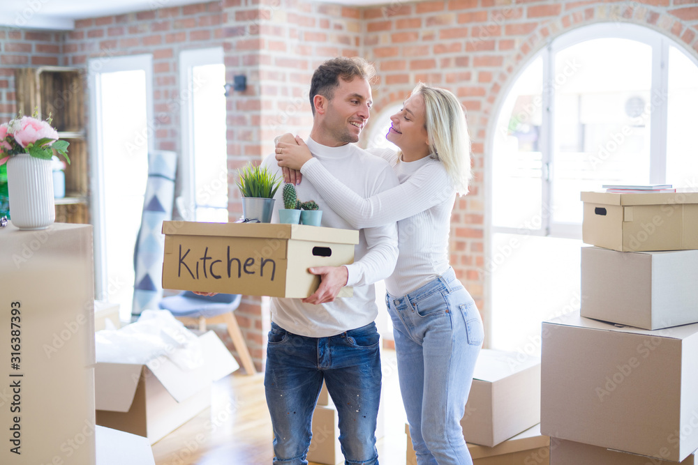 Young beautiful couple moving cardboard boxes at new home Young beautiful couple moving cardboard boxes at new home