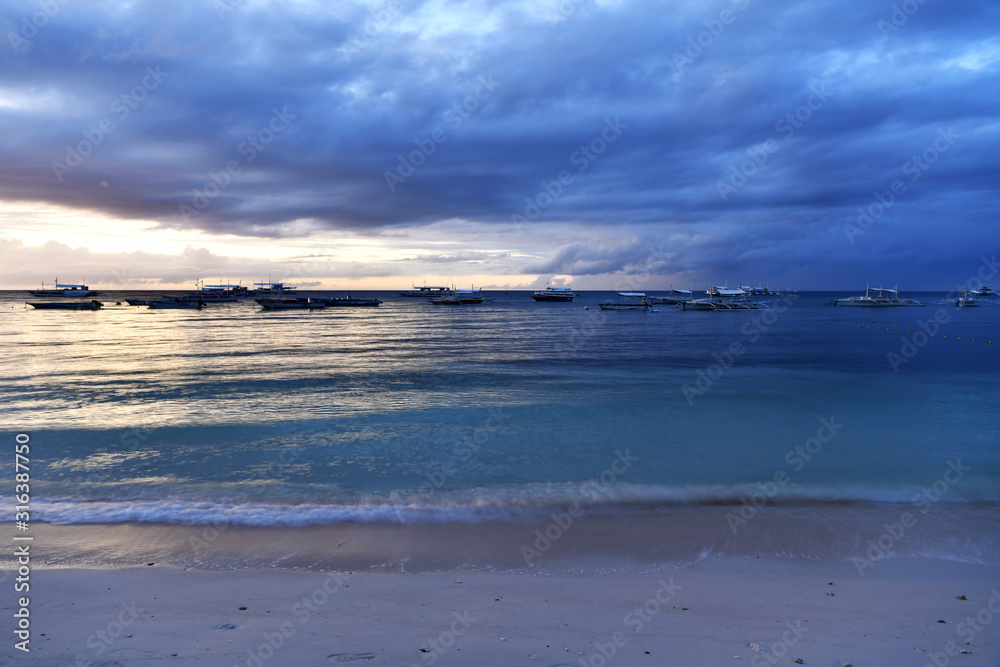 Fototapeta premium sunrise on a tropical island with a white sandy beach in the philippines