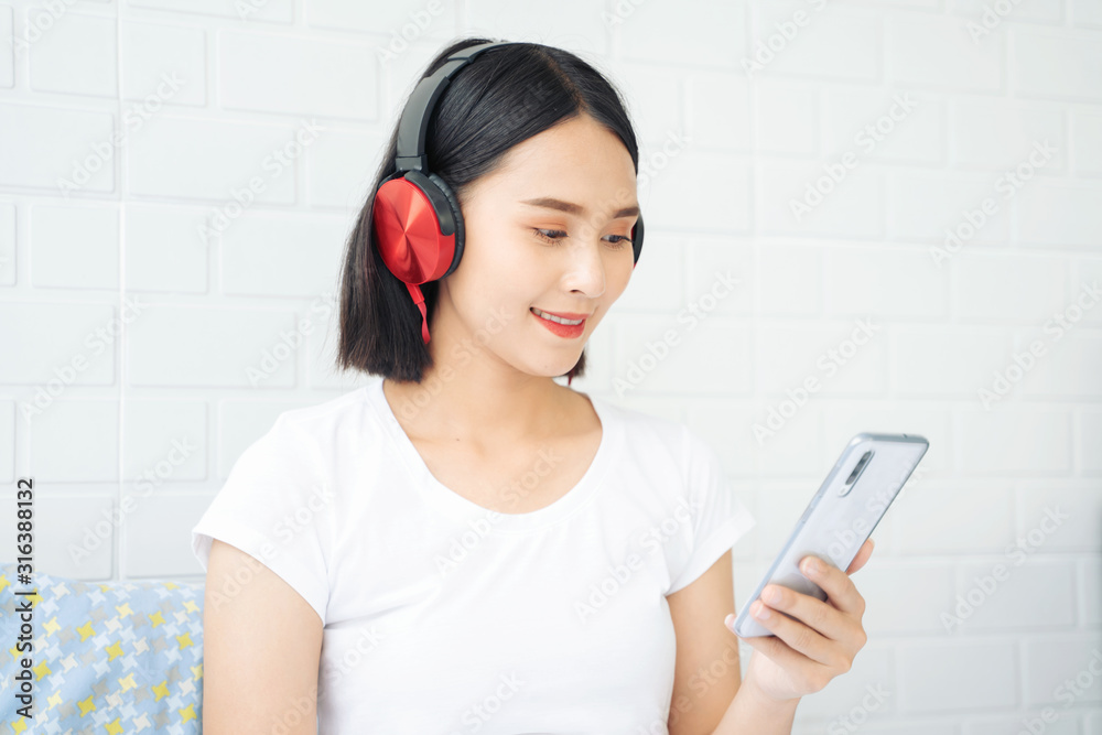 relax and leisure concept, Beautiful young Thai Asian woman with headphone or earphone relaxing on the bed, she is listening to music using a tablet and lying down with eyes closed in bedroom relax and leisure concept, Beautiful young Thai Asian woman with headphone or earphone relaxing on the bed, she is listening to music using a tablet and lying down with eyes closed in bedroom