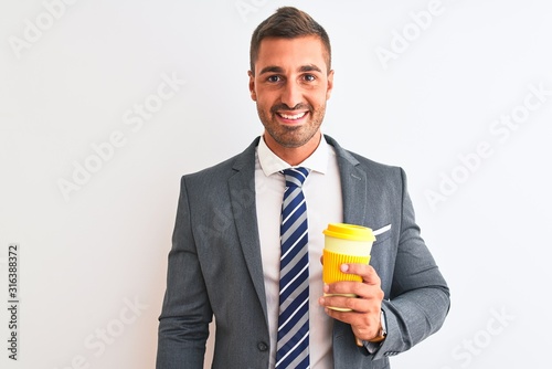 Young handsome business man drinking take away coffee over isolated background with a happy face standing and smiling with a confident smile showing teeth