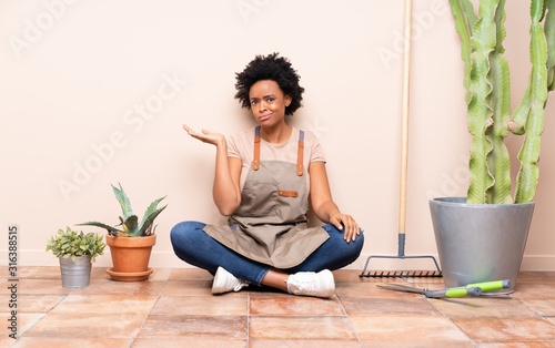 Gardener woman sitting on the floor unhappy for not understand something