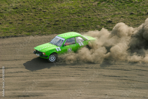 Rally car slide on a dusty racing track