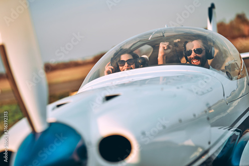 Young woman and pilot in in the cockpit of a plane © HBS