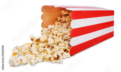 Delicious popcorn and overturned red striped paper popcorn bucket isolated on white background.