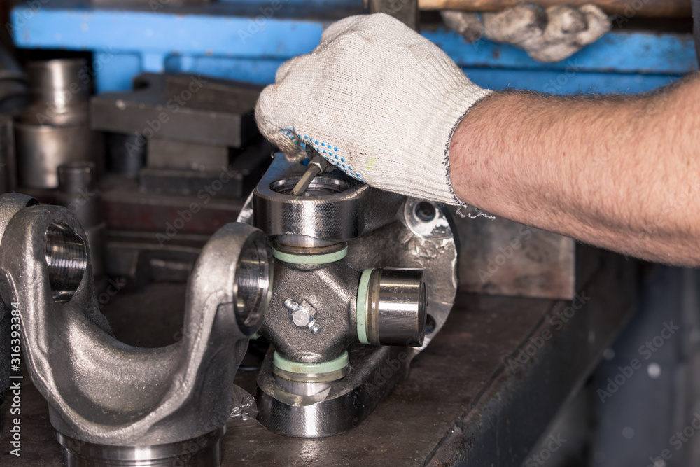 Worker repairs a car part in a workshop. Worker repairs a car part in a workshop.