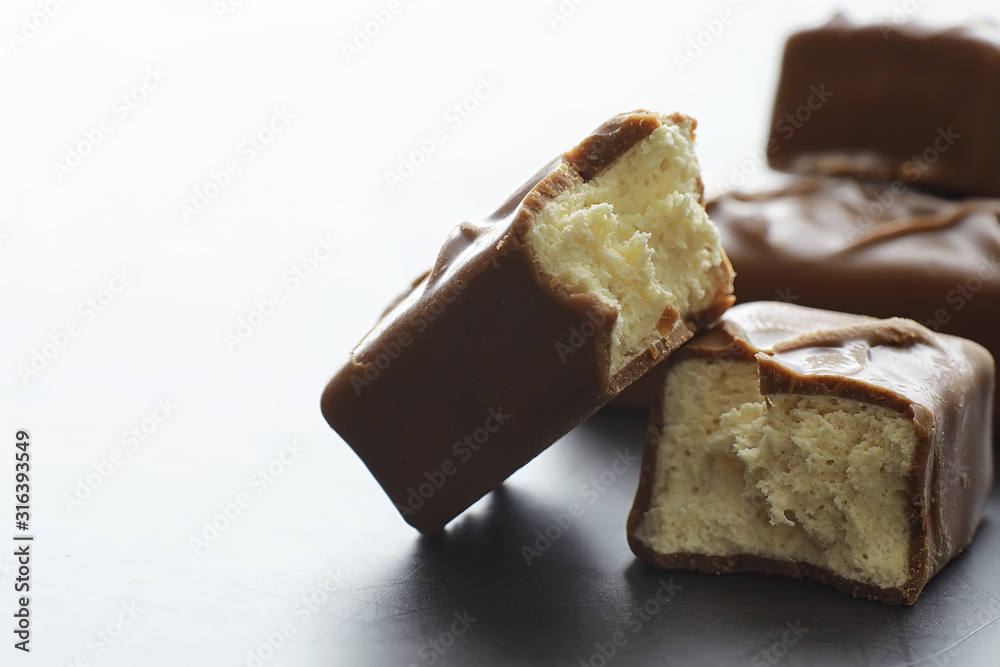 Chocolate bars on a black background in backlight. Chocolate with filling. Sweet sweets for snack and tea. Chocolate bars on a black background in backlight. Chocolate with filling. Sweet sweets for snack and tea.