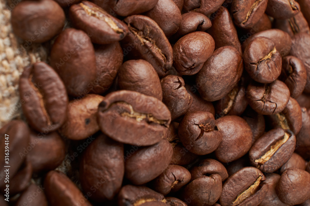 Fototapeta premium Filiżanka kawy i ziarna kawy na stole z bliska