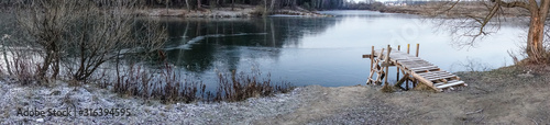 Winter landscape. The frozen lake is covered with new clean ice. panorama
