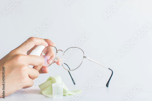 girl hand cleaning glasses lens with white background, cleaning glasses concept.