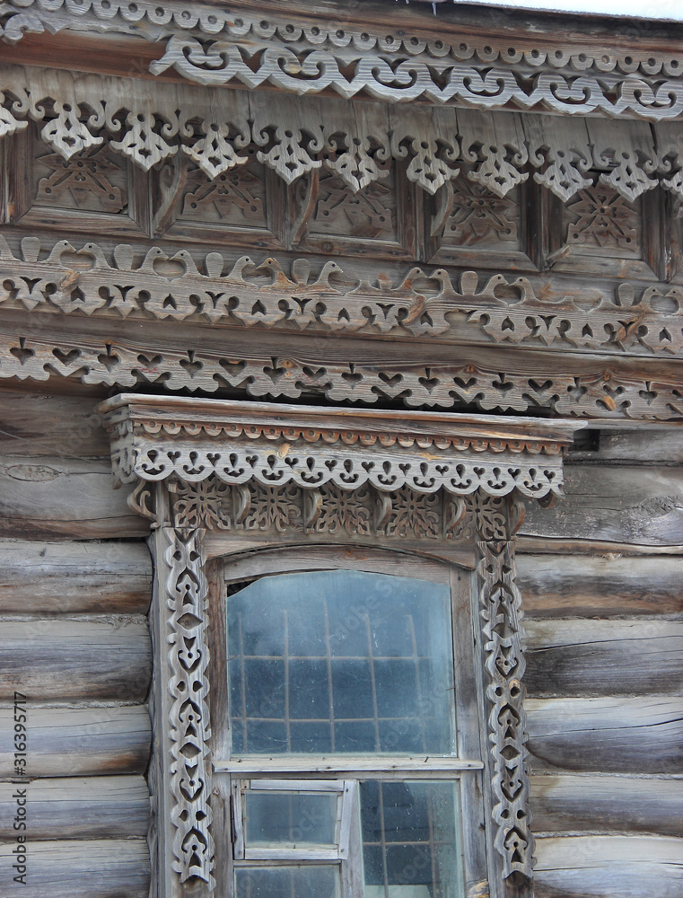 Naklejka premium Openwork cornice and window frames on an old wooden house