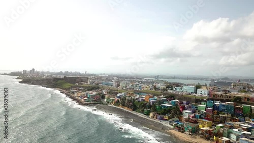 Drone Aerial View on San Juan Puerto Rico City Waterfront, Colorful Houses in La Perla District, Castilo De San Cristobal and Downtown Skyline photo