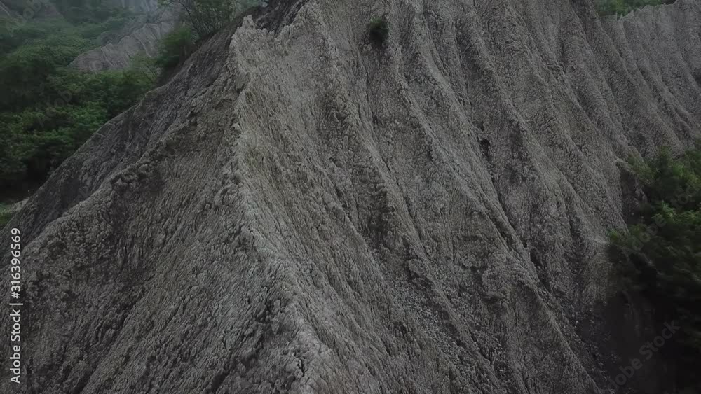 Pull Back Aerial View on Stunning Mudstone Petrified Hills in Tianliao Moon World Landscape Park, Taiwan
