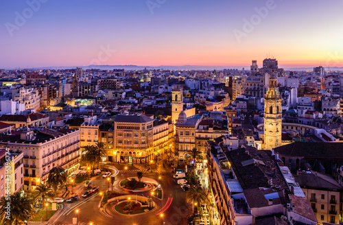 Sightseeing of Spain. Aerial view of Valencia at sunset. Illuminated Plaza de la Reina, cityscape of Valencia.