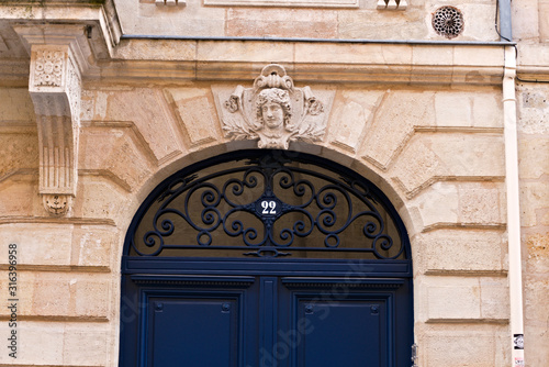 Upper section of an old, wooden, closed, dark blue door with number 22