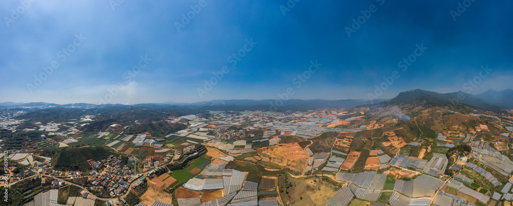 Dalat or Da Lat, Vietnam aerial panorama of agricultural area showing farms, mountains and greenhouses. This highland area is famous for producing arabica coffee, fruit, vegetables and flowers
