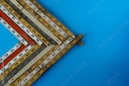 A vector of folding rulers in metric and inches on blue background. Concepts of business graph or chart representing accuracy, measurement, increase, growth and results with copy space.