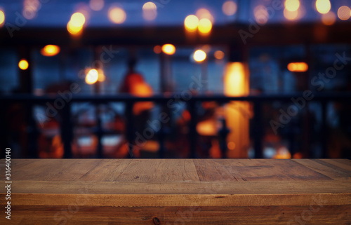 background Image of wooden table in front of abstract blurred restaurant lights