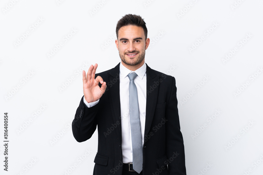 Young business man over isolated background showing an ok sign with fingers Young business man over isolated background showing an ok sign with fingers