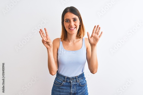 Beautiful redhead woman standing over isolated background showing and pointing up with fingers number eight while smiling confident and happy.