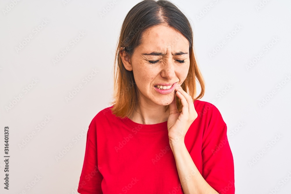 Beautiful redhead woman wearing casual red t-shirt over isolated background touching mouth with hand with painful expression because of toothache or dental illness on teeth. Dentist concept. Beautiful redhead woman wearing casual red t-shirt over isolated background touching mouth with hand with painful expression because of toothache or dental illness on teeth. Dentist concept.