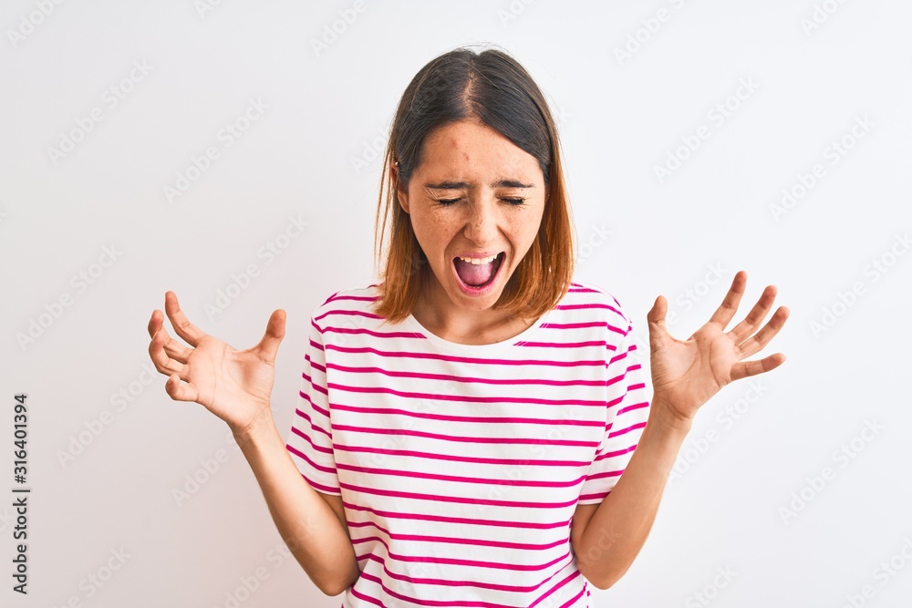 Beautiful redhead woman wearing casual striped pink t-shirt over isolated background celebrating mad and crazy for success with arms raised and closed eyes screaming excited. Winner concept Beautiful redhead woman wearing casual striped pink t-shirt over isolated background celebrating mad and crazy for success with arms raised and closed eyes screaming excited. Winner concept