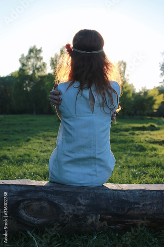 A girl on a walk in an autumn park. Young red-haired girl in the spring on nature.