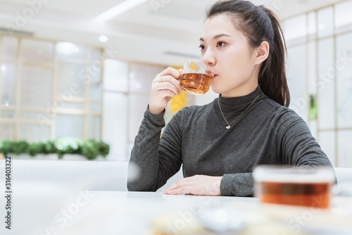 Young asian female drinking tea in restaurant