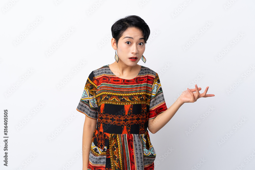 Young Asian girl with a colorful dress over isolated white background making doubts gesture Young Asian girl with a colorful dress over isolated white background making doubts gesture