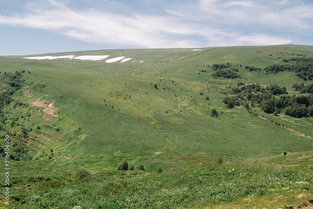 Summer view of the plateau lago naki with snow. Beautiful clouds and mountain in a blue haze.