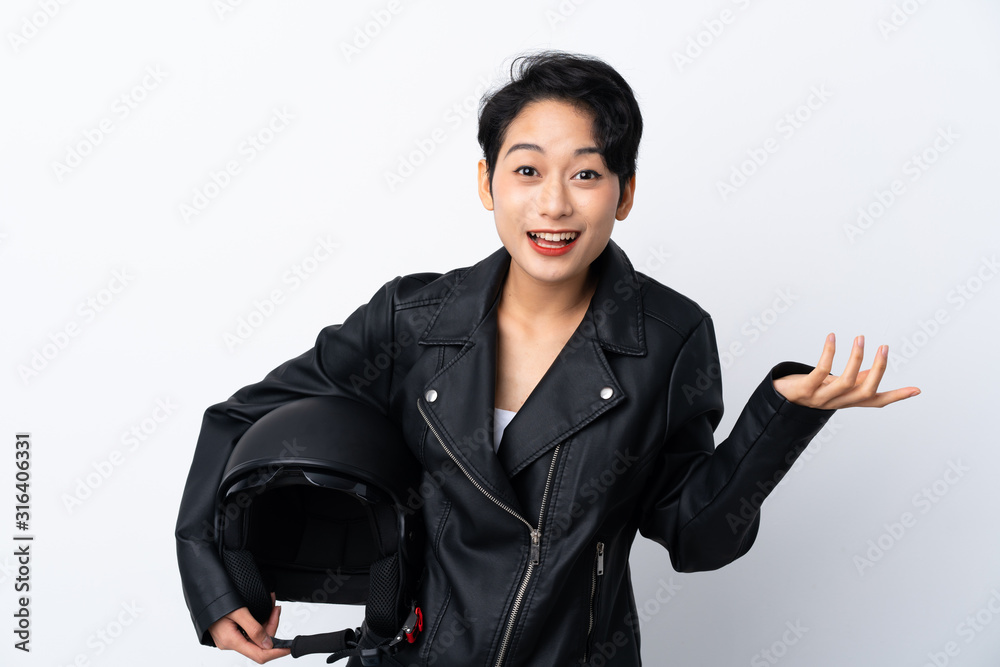 Young Asian girl with a motorcycle helmet over isolated white background with shocked facial expression Young Asian girl with a motorcycle helmet over isolated white background with shocked facial expression